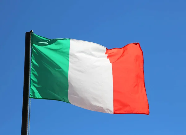 Italienische Flagge weht am blauen Himmel mit leuchtend rotem und weißgrünem C — Stockfoto