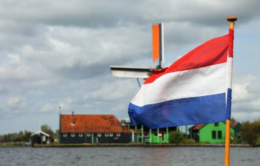 Hollandalı bayrakları sallayarak ve yel değirmeni pl arka planda