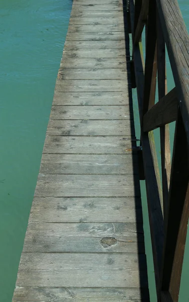 Langer Holzsteg ohne Menschen über dem Wasser schwebt — Stockfoto