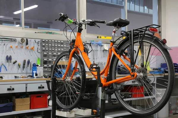 Fiets reparatie workshop met een oranje fiets — Stockfoto