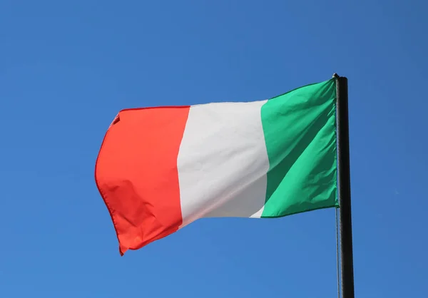 Grande bandeira italiana acenando no céu azul com vermelho e branco col verde — Fotografia de Stock