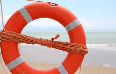 turuncu yaşam-şamandıra kurtarma ipi ile deniz kenarında