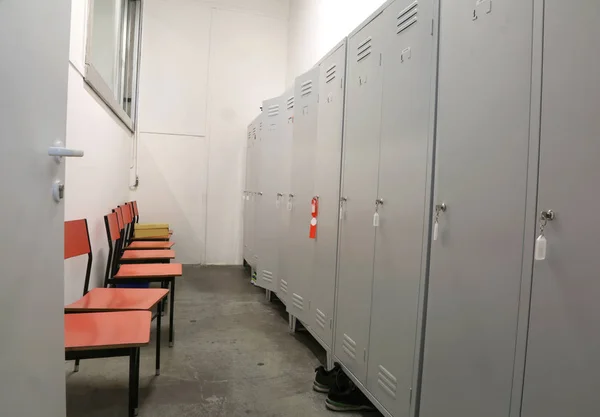 Metalen lockers en sommige plastic stoelen in de kleedkamer van een fabriek — Stockfoto