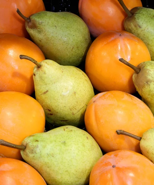 Grönt päron och orange persimon — Stockfoto