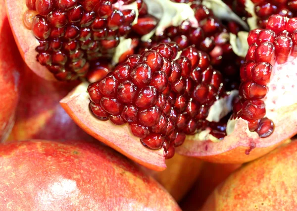 Fondo de muchos frutos de granada con semillas rojas en el interior — Foto de Stock