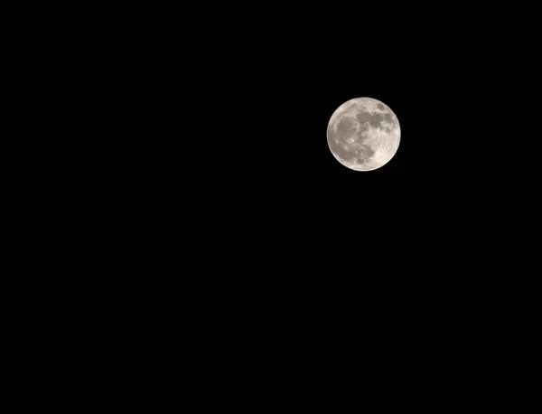 Великий повний місяць дуже яскравий в чорному небі — стокове фото