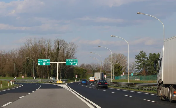 Italienische Autobahn mit dem Schild mit der Wegbeschreibung nach Udine und — Stockfoto