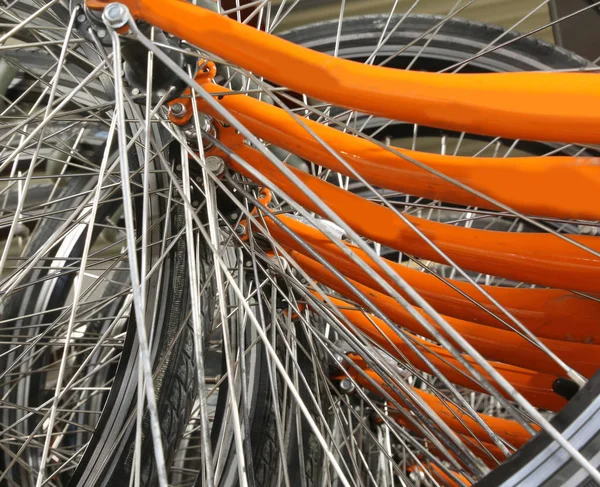 Many metallic spokes of orange bicycle — Stock Photo, Image