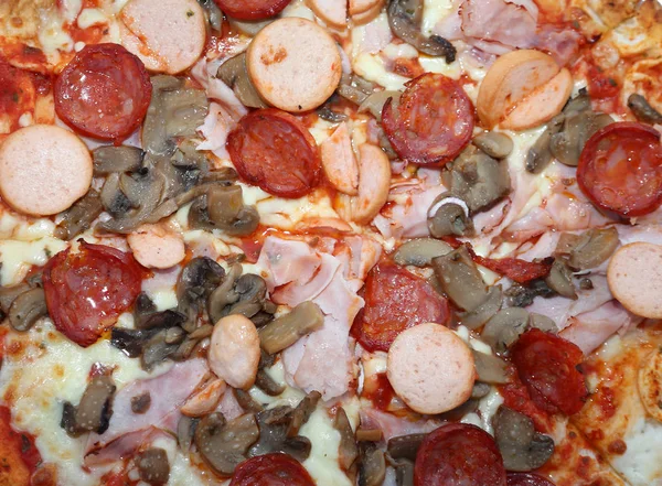 Tsty takeaway pizza z pieczarkami wurstel pikantnym salami i szynka — Zdjęcie stockowe