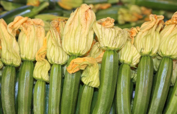 Färska gröna zucchini med blomma på försäljning i grönsakshandlare — Stockfoto