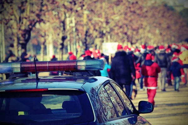 Polisbilen och många människor med röd hatt med vintage effekt — Stockfoto