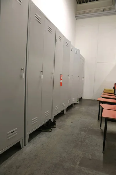 Kluisjes en plastic stoelen in de kleedkamer van een fabriek zonder th — Stockfoto