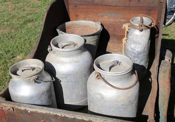 Latas de leche de aluminio viejas para transportar leche fresca en una c de madera —  Fotos de Stock