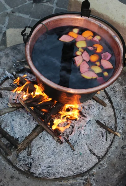 Hot MULLED WINE on the big cauldron over the bonfire during the — Stock Photo, Image