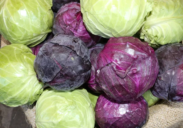 Зеленая и фиолетовая капуста для продажи внутри джутового мешка — стоковое фото