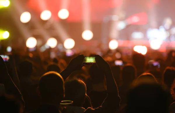 Homme utilisant le téléphone intelligent au concert en direct et beaucoup de gens — Photo