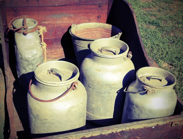 Latas de leche de aluminio viejas para transportar leche fresca en una c de madera —  Fotos de Stock