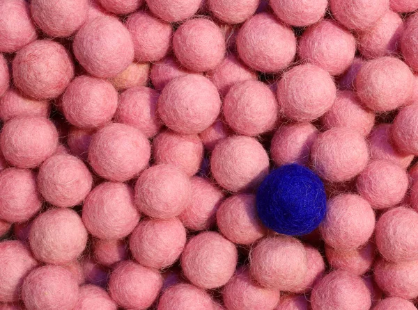 Ein blauer Ball im Hintergrund vieler pinkfarbener Kugeln — Stockfoto