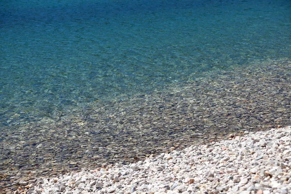 Чиста вода альпійського озера з галькою — стокове фото