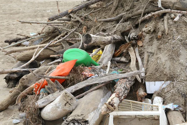 Debris and dead wood with dirt and pieces of plastic collected o — Stock Photo, Image