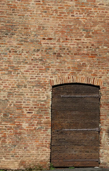Τοίχο από τούβλα και μια παλιά ξύλινη πόρτα — Φωτογραφία Αρχείου