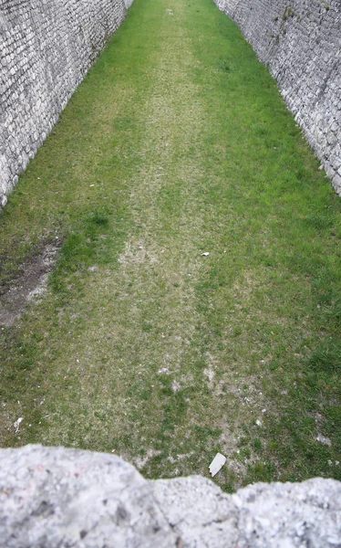 Parede de pedra que faz fronteira com uma cidade medieval com um fosso — Fotografia de Stock