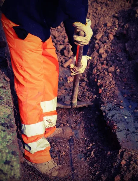 Trabajador con ropa de alta visibilidad mientras trabaja en una carretera con — Foto de Stock