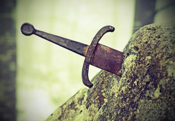Legendariska Excalibur svärdet i stenen med vintage effekt — Stockfoto