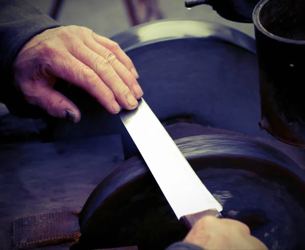 Amoladora con las manos afilar una hoja de un cuchillo con effec vintage — Foto de Stock