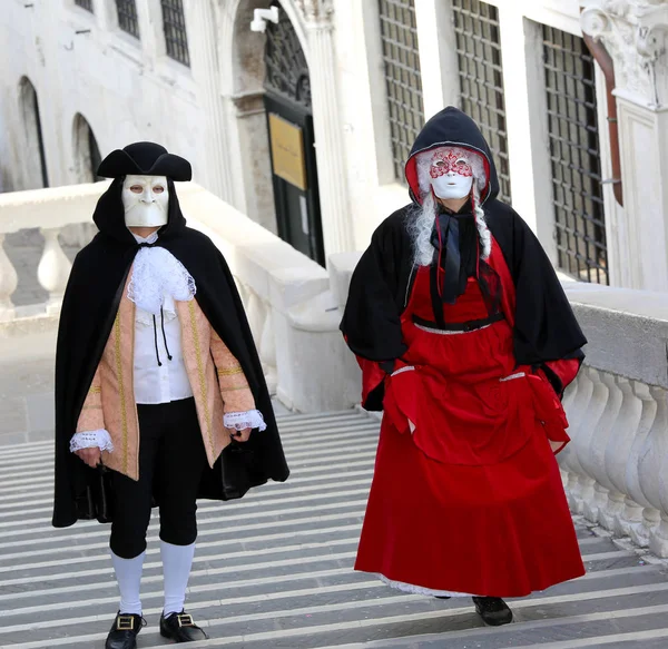 Venice, Italy - February 5, 2018: masked lovers walk on the step — Stock Photo, Image