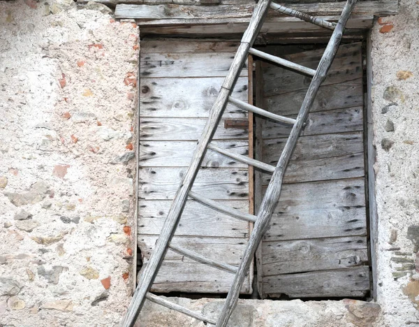 Alte Holztür und eine lange alte Leiter im Bauernhaus — Stockfoto