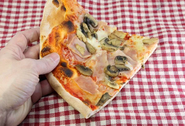Rękę, chwytając kawałek pizzy z mozzarellą grzyby szynka i — Zdjęcie stockowe