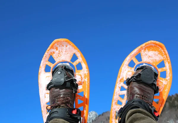 Kış ve gökyüzü arka plan üzerinde turuncu kar ayakkabıları — Stok fotoğraf