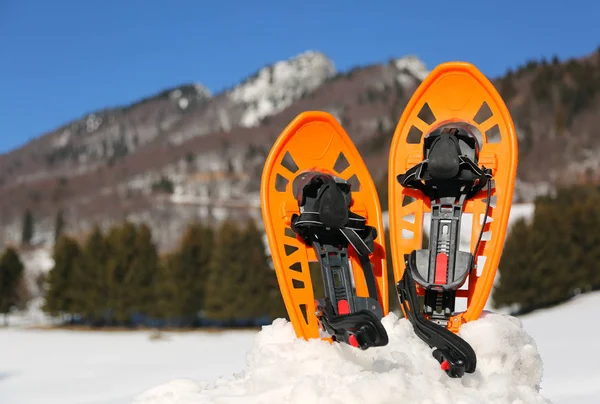 Duas sandálias de neve laranja nas montanhas — Fotografia de Stock