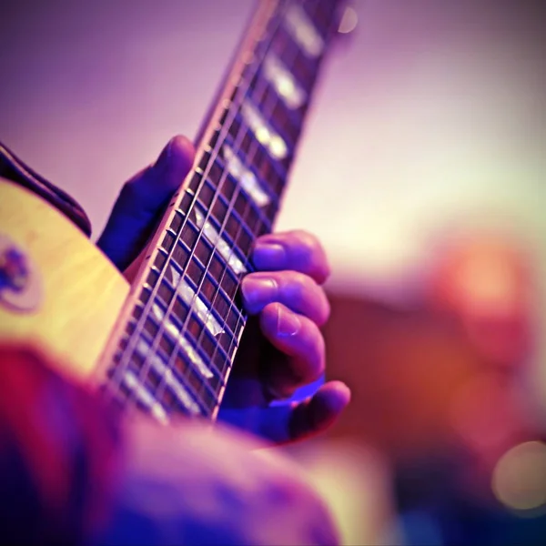 Guitarist plays electric guitar on stage with vintage effect — Stock Photo, Image