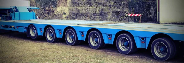 Zeer lange blauwe vrachtwagen met zes assen van wielen met vintage effe — Stockfoto