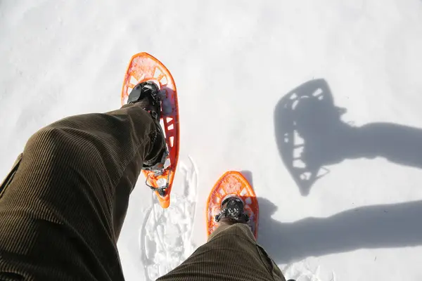 Man with corduroy trousers with snowshoes — Stock Photo, Image