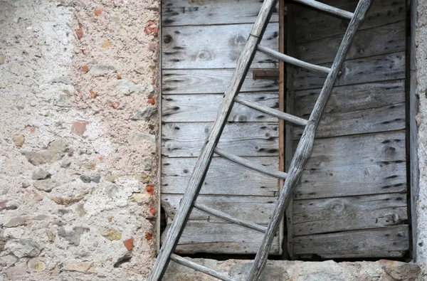 Ländliche Szene mit uralter Leiter und einer alten Holztür — Stockfoto