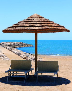 Bambu ve saman ile yapılan şemsiye ile plaj