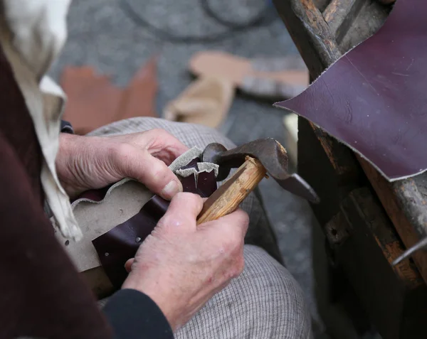 Cobbler repairs the shoe with an ancient hammer and the piece of — Stock Photo, Image