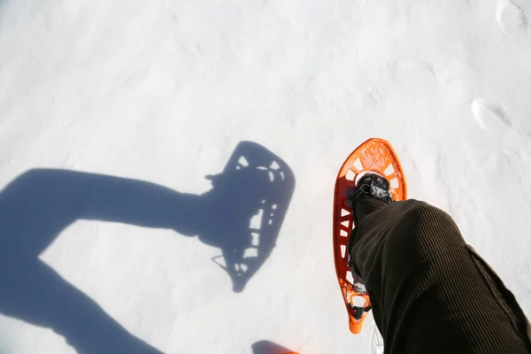Man walks with corduroy pants with snowshoes on the white snow — Stock Photo, Image