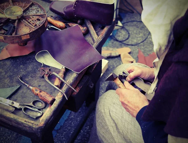 Старий скеплер під час ремонту взуття шматочком шкіри — стокове фото