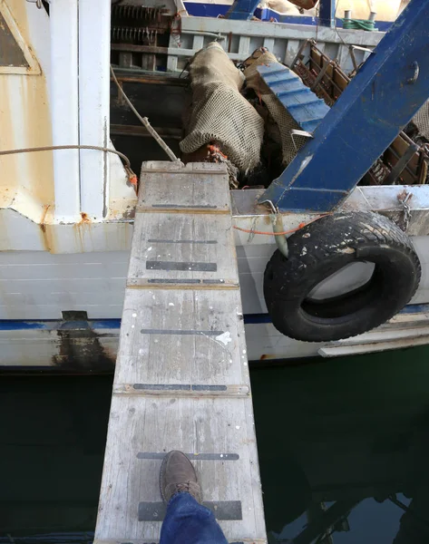 Ένα πόδι ενός άνδρα πάνω σε μια γέφυρα για πεζούς να πάνε με σκάφος — Φωτογραφία Αρχείου