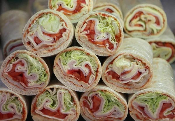 Hengerelt szendvicseket a sonka és a sajt saláta egy jó snack — Stock Fotó