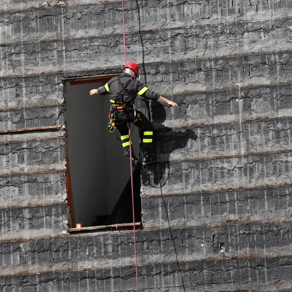 Feuerwehrmann klettert eine Wand hoch — Stockfoto