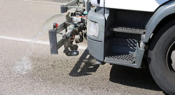 Water splash van vrachtwagen voor het wassen van de wegen — Stockfoto