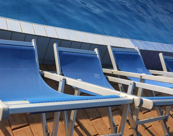 Modrá lehátka na okraji bazénu — Stock fotografie