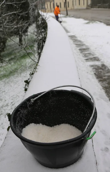 Bucket with salt to melt ice from the sidewalk — Stock Photo, Image