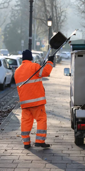 Sweeper with an orange jacket collecting rubbish — Stock Photo, Image