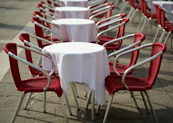 Asztalok és piros székek, egy szabadban történő kávézóban — Stock Fotó